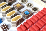 Close-up of board game pieces including dice and tiles on a white surface