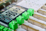 Board game with green dice and a digital display