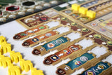 Close-up of a board game with track layout and yellow player pieces.