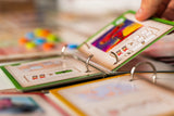 Card game with colorful cards in a ring-bound album