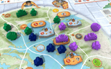 Board game with colorful pieces and markers on a map-like board
