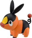 Toy figure of a black and orange character with a yellow patch on a white background