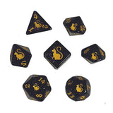 Set of black dice with gold cat symbols on a white background