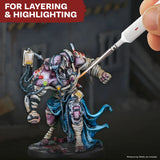 Miniature figure being painted with a brush, set against a dark background.