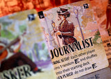 Card featuring a character labeled 'Journalist' from a board game, with other cards in the background.
