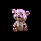 Small pig figurine with a metallic finish on a black background