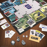 Clue board game setup on a wooden table with cards and pieces.