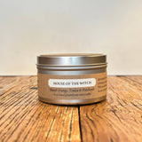 Candle in a tin with a label on a wooden surface
