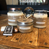 Three candles labeled 'House of the Witch' on a wooden surface with a crystal ball and other items in the background.