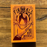 Fireball whiskey label with a hand holding a flame on an orange background, placed on a wooden surface.