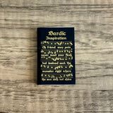 Black book titled 'Bardic Inspiration' with gold text on a wooden surface