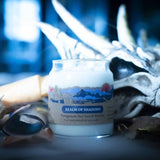Candle labeled 'Realm of Shadows' with decorative elements in the background