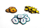 Collection of star-shaped and shield-like pins on a white background