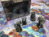 Battletech miniatures on a game mat with a box in the background
