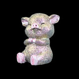Iridescent pig figurine on a black background