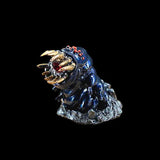 Metallic creature figurine with sharp teeth on a black background
