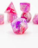 Set of pink and purple polyhedral dice on a white background