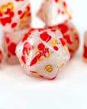 Close-up of red and white dice with gold numbers on a white background