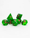Set of green polyhedral dice with pink floral patterns on a white background