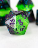 Green and purple polyhedral dice with numbers on a white surface