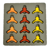 Silicone mold with small figurine shapes in orange, red, and yellow on a gray background