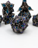 Hexagonal metal dice with blue and purple enameled faces on a white background
