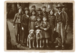 Vintage photograph of a group of people and two dogs posing together.