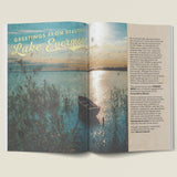Open book with a scenic illustration of a lake and boat, titled 'Greetings from Beautiful Lake Evermore'.
