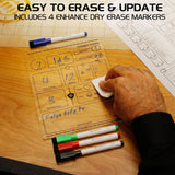 Dry erase board with markers and a hand erasing, on a wooden surface.