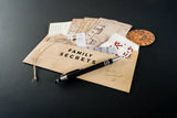 Envelopes labeled 'Family Secrets' with a pen on a dark surface