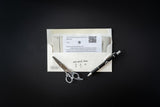 Scissors, pen, and business card on a black background