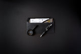 Black envelope with stationery items on a dark background
