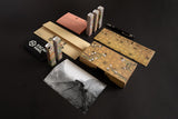 Collection of gaming components including a map, cards, and a pen on a dark surface.