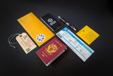 Collection of travel-related items including a passport, ticket, and wallet on a dark background