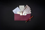 Open red envelope with letters and a pen on a black background