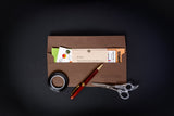Brown leather wallet with stationery items on a black background
