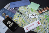 Collection of items including a phone, map, and cards on a dark surface