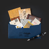 Blue envelope with vintage-style letters and a pen on a dark background