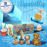 Cupcake-themed product set with dice, dog enamel pin, and packaging on a blue background.