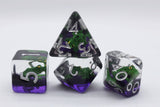 Three transparent polyhedral gaming dice with purple and green frog designs, displayed on a light gray background.
