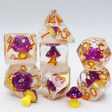 A set of transparent polyhedral dice with purple and yellow mushroom motifs embedded inside, photographed on a clean white background.
