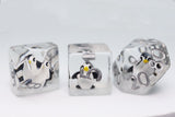 Three clear acrylic polyhedral dice with silver-colored metallic numbering and penguin illustrations, displayed on a white surface.