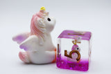 Unicorn-shaped piggy bank with a pink and purple block featuring a unicorn design on a white background