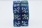 A stack of translucent blue and green polyhedral dice with white plus/minus numbering, photographed on a clean white background.