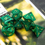 Set of green marbled dice with gold numbers on a blurred background