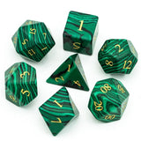 Set of green marbled polyhedral dice with gold numbers on a white background