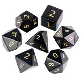 Set of black polyhedral dice with gold numbers on a white background