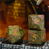 Three green stone dice with gold numbers on a dark surface