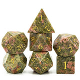 Set of green stone dice with gold numbers on a white background