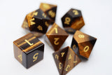 Set of brown polyhedral dice with gold numbers on a white background